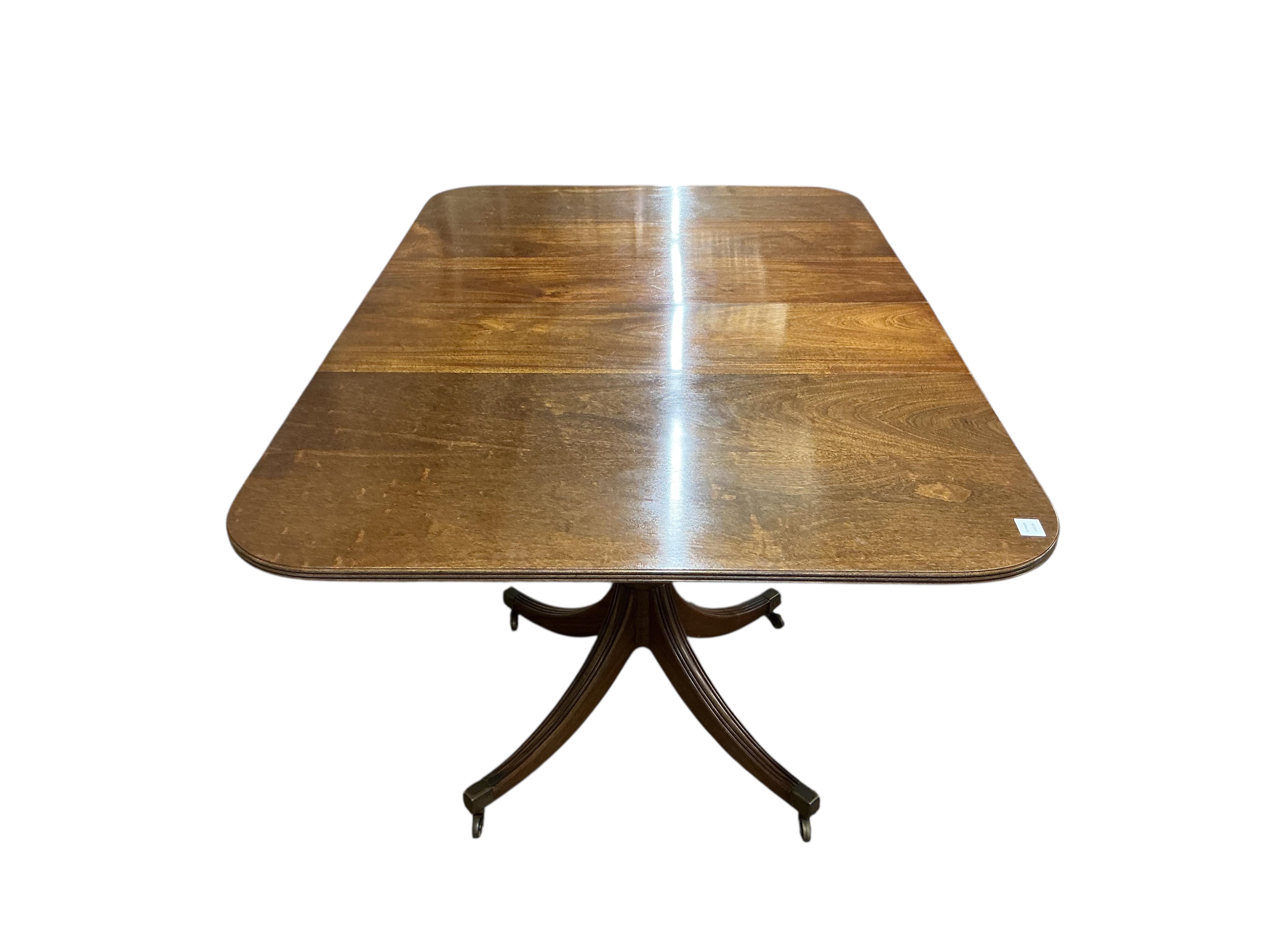A Regency style mahogany twin pillar extending dining table, width 295cm extended, two spare leaves, depth 114cm, height 74cm